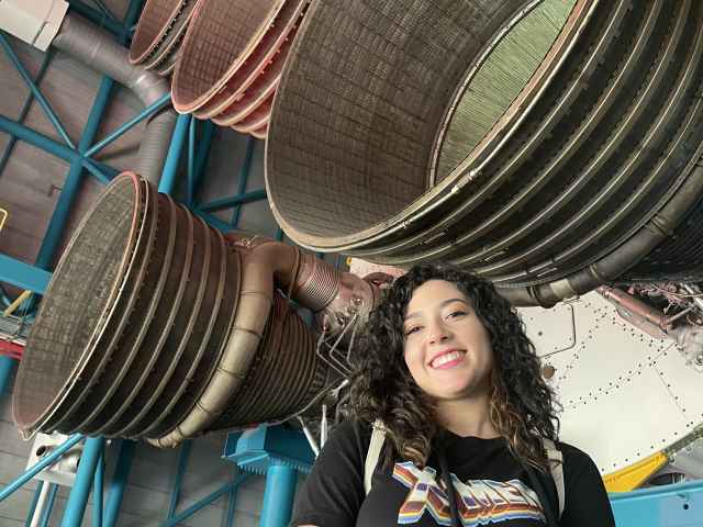 Yairette Quinones stands in front of huge rocket thrusters.