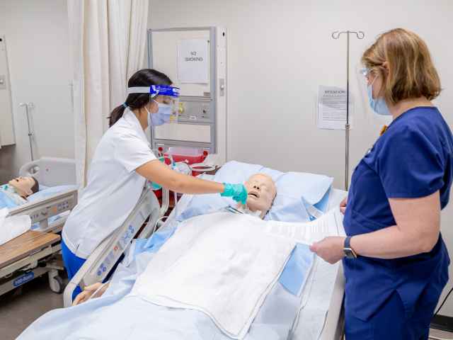 A student in Seminole State's nursing program practices her skills on a patient simulator under the supervision of a nursing professor.