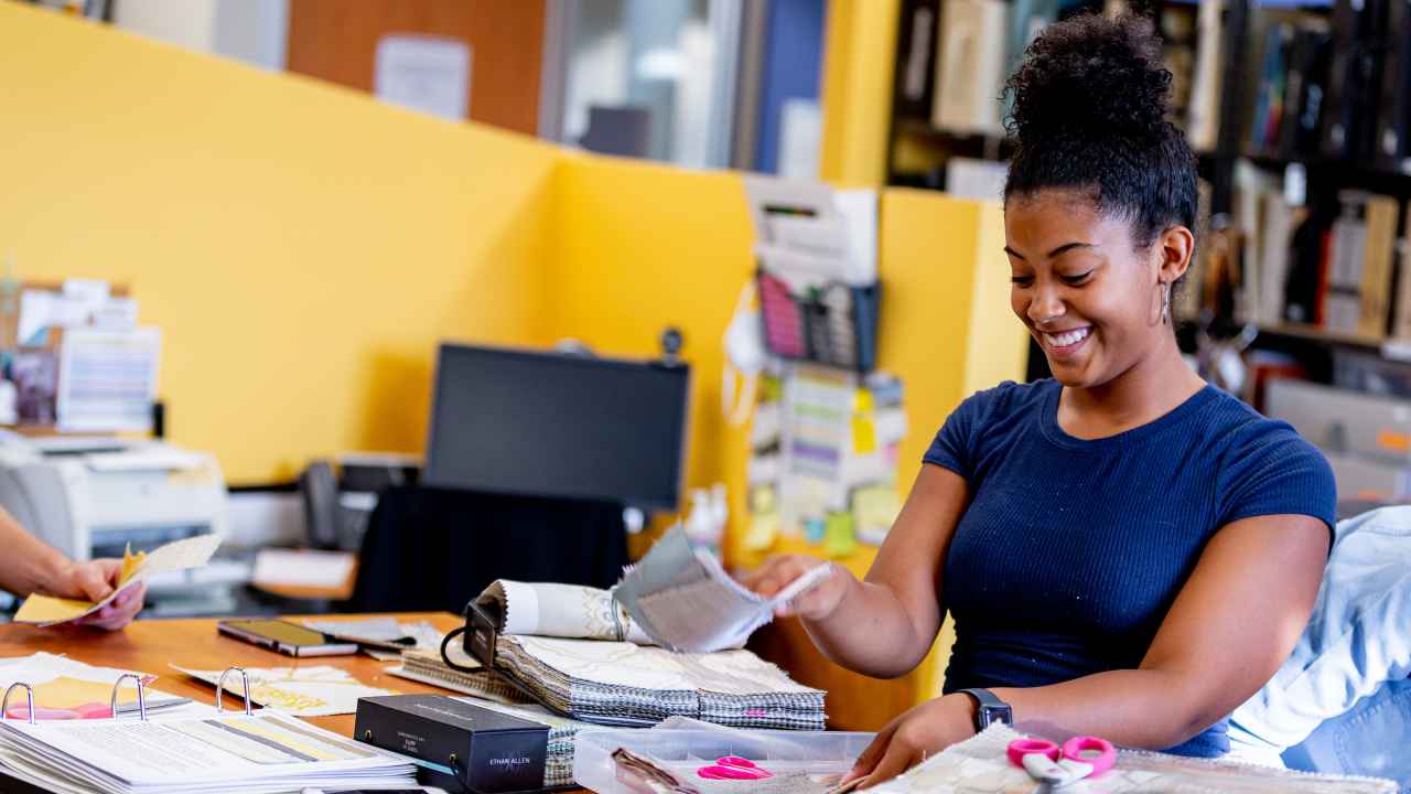 Woman sorts through fabric swatches in the interior design program.