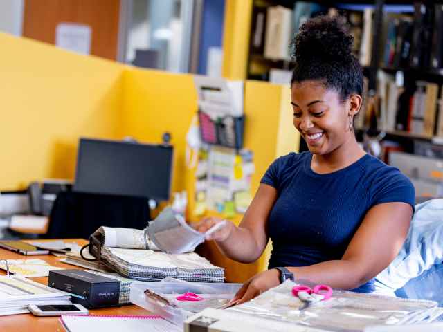 Woman sorts through fabric swatches in the interior design program.