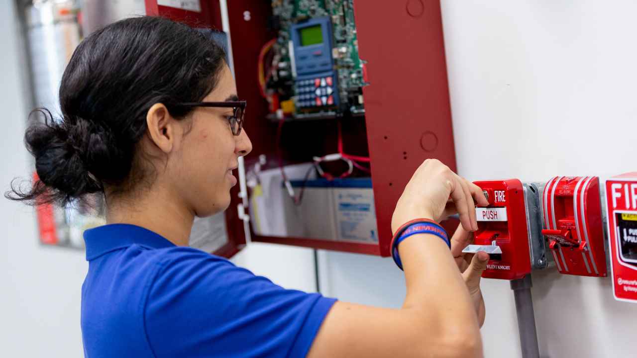 A student works on a fire sprinkler