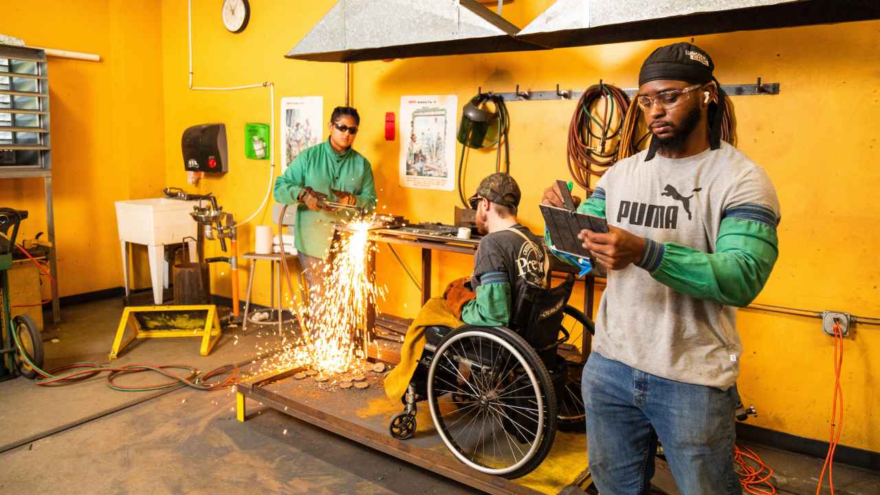 Three welding students work on a project