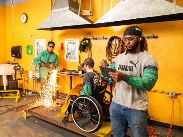 Three welding students work on a project