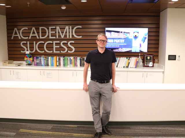 Nathan Moon stands in the SLM ASC front desk