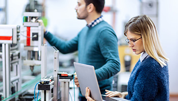 A man and woman working in an AI computer lab