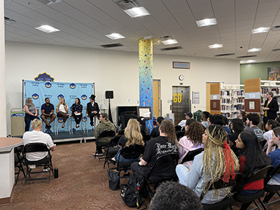 Group of students sitting in the library, listening to a panel of professors reading the Declaration of Independence at a Lunchbrary session