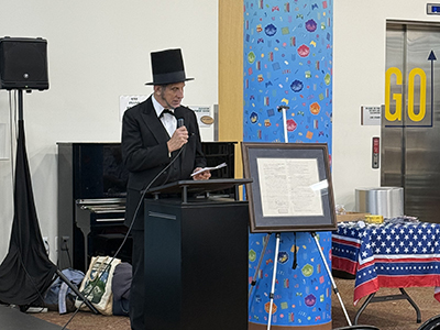Jordan Camenker, a professor of legal studies, dressed as Abraham Lincoln, and reading the Declaration of Independence at a Lunchbrary session