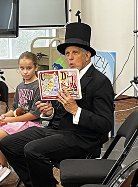 Summer Storytime session where Jordan Camenker, a professor of legal studies, is dressed as Abraham Lincoln
