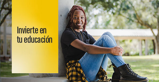 Comprométase con su educación mediante una imagen de un estudiante sentado junto a una columna en el campus.