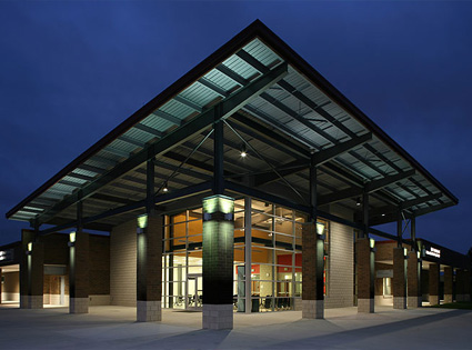 Exterior of a modern campus building with large glass windows, photographed at night.