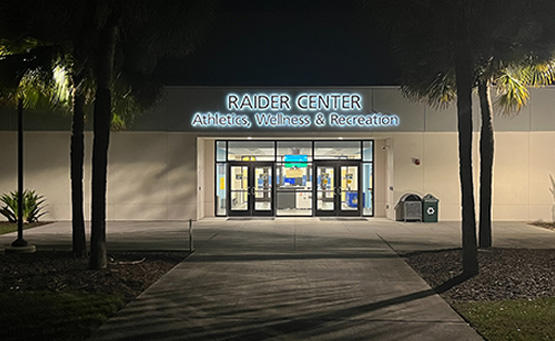 Front entrance of the Raider Center for Athletics, Wellness, and Recreation illuminated at night