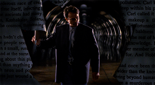 Movie poster of In the Mouth of Madness showing actor Sam Neil, wearing a dark suit, walking and looking to the side, against a dark tunnel background with newspaper images on the sides of the background