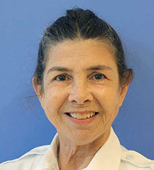 Person wearing a white collared shirt against a blue background.