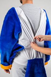 A person standing in the Rally suit and showing another person zipping the back of the shirt.